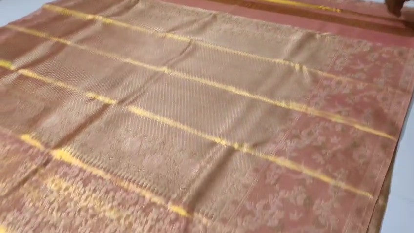 Peach Kanchipuram handloom tissue brocade silk bridal saree featuring an intricate all-over gold woven floral design and traditional zari borders.