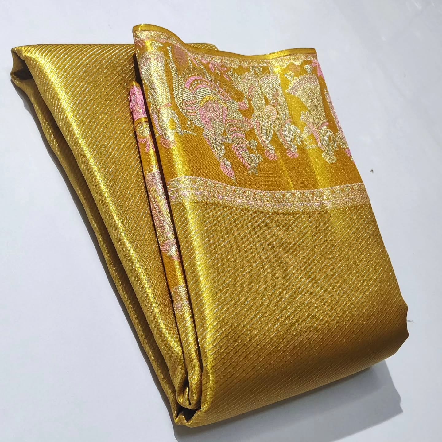 Luminous gold Kanchipuram handloom tissue brocade silk saree featuring intricate zari weaving and a grand Kalyana Pallakku design.
