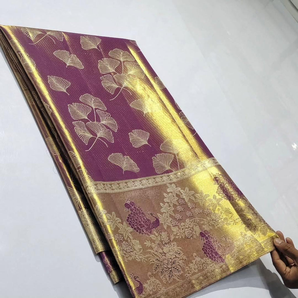 Plum Kanchipuram handloom tissue brocade silk saree with gold tissue sheen, intricate ginkgo leaf body motifs, and an antique gold border featuring floral motifs.