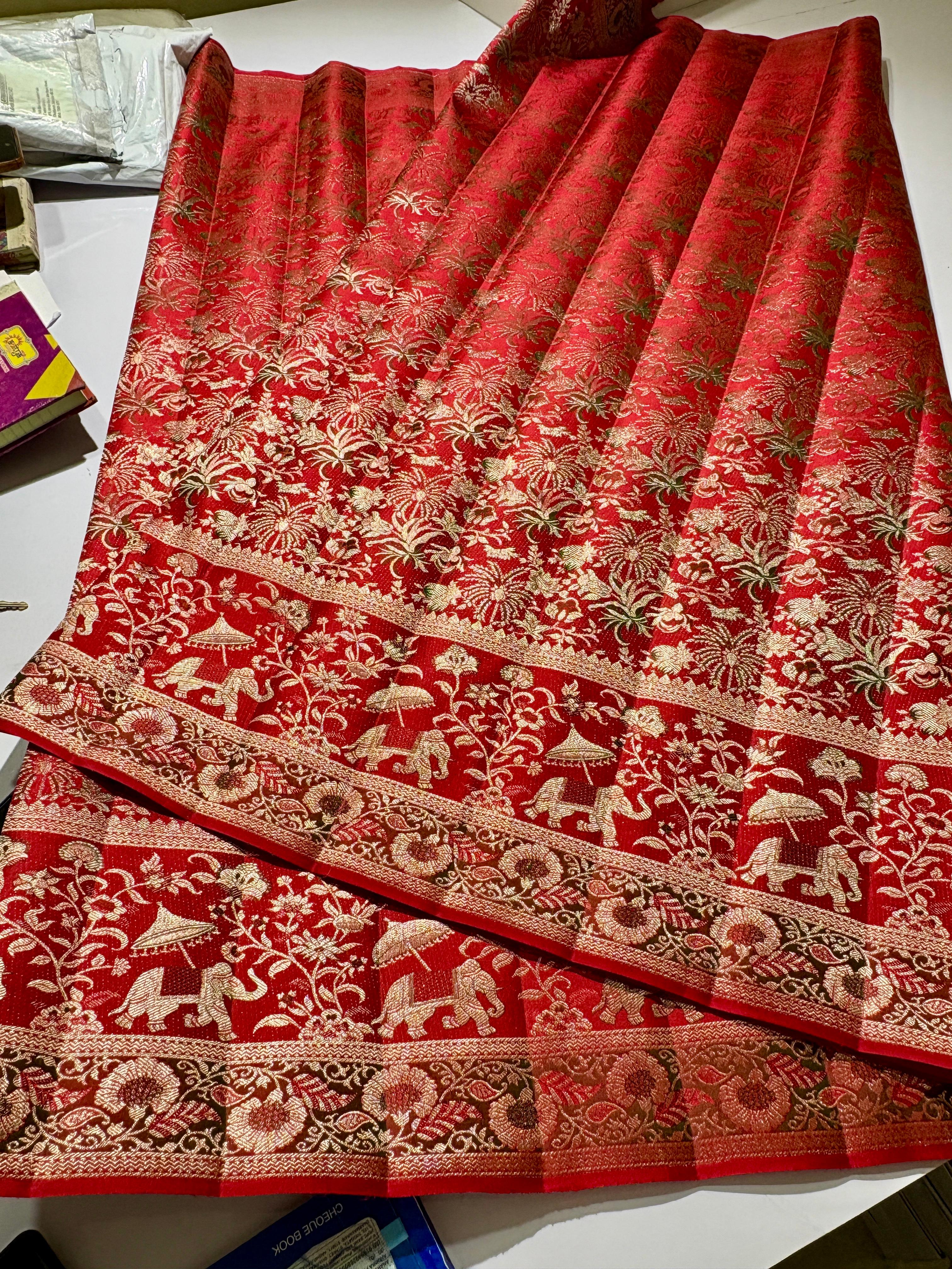 Vibrant red Kanchipuram handloom silk saree featuring detailed 1G gold brocade and multicolored Resham Meenakari work including elephant and floral vine patterns.