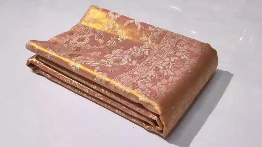 A close-up view of a Dusty Rose Kanchipuram tissue silk saree featuring elegant gold floral brocade patterns and authentic handloom texture.