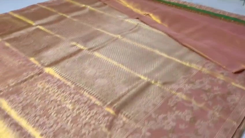 A close-up view of a Dusty Rose Kanchipuram tissue silk saree featuring elegant gold floral brocade patterns and authentic handloom texture.