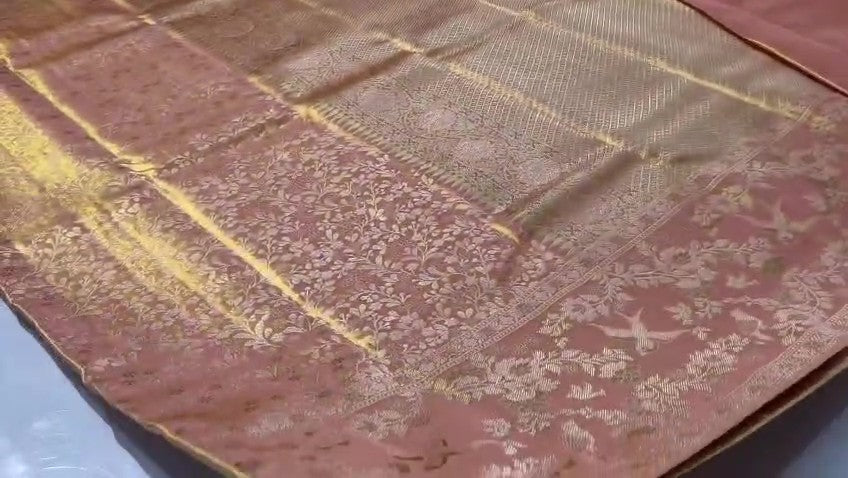 A close-up view of a Dusty Rose Kanchipuram tissue silk saree featuring elegant gold floral brocade patterns and authentic handloom texture.
