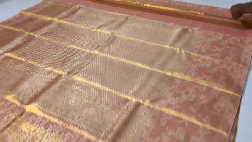 A close-up view of a Dusty Rose Kanchipuram tissue silk saree featuring elegant gold floral brocade patterns and authentic handloom texture.