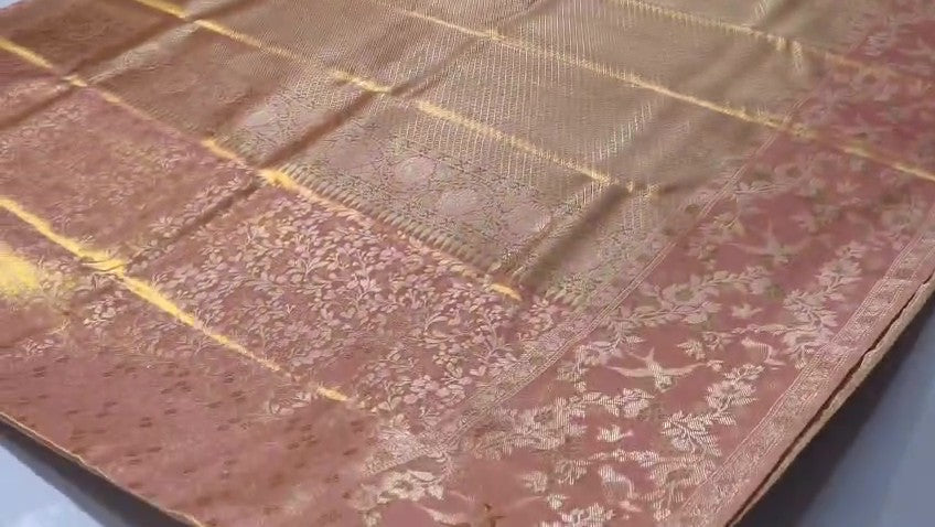 A close-up view of a Dusty Rose Kanchipuram tissue silk saree featuring elegant gold floral brocade patterns and authentic handloom texture.