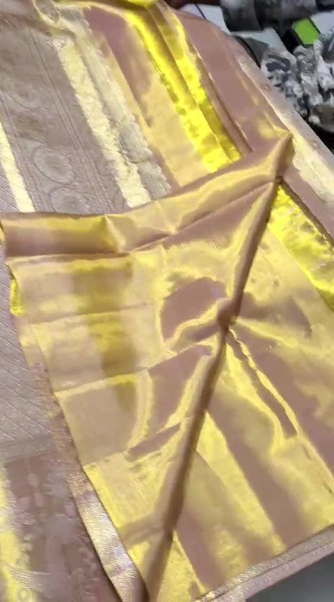A close-up of a luxurious gold Kanchipuram tissue silk saree featuring intricate metallic brocade weaving, authentic Silk Mark certification, and a grand bridal luster.