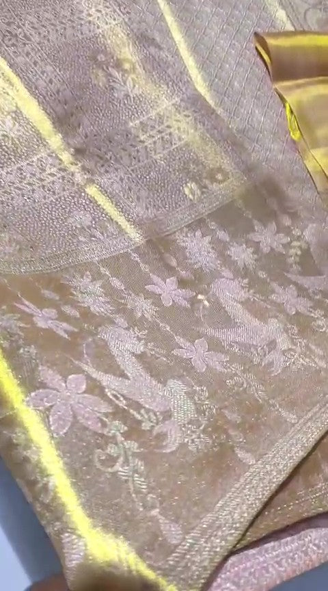 A close-up of a luxurious gold Kanchipuram tissue silk saree featuring intricate metallic brocade weaving, authentic Silk Mark certification, and a grand bridal luster.