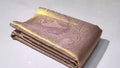 Neatly folded baby pink Kanchipuram handloom tissue silk saree displaying the rich pallu and shimmering metallic finish.