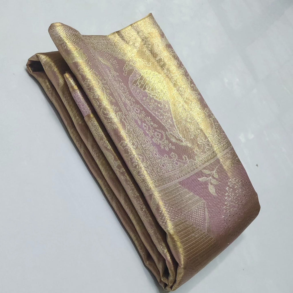 Close-up of the baby pink Kanchipuram tissue silk saree showcasing intricate gold brocade patterns and edge-to-edge Meenakari work.