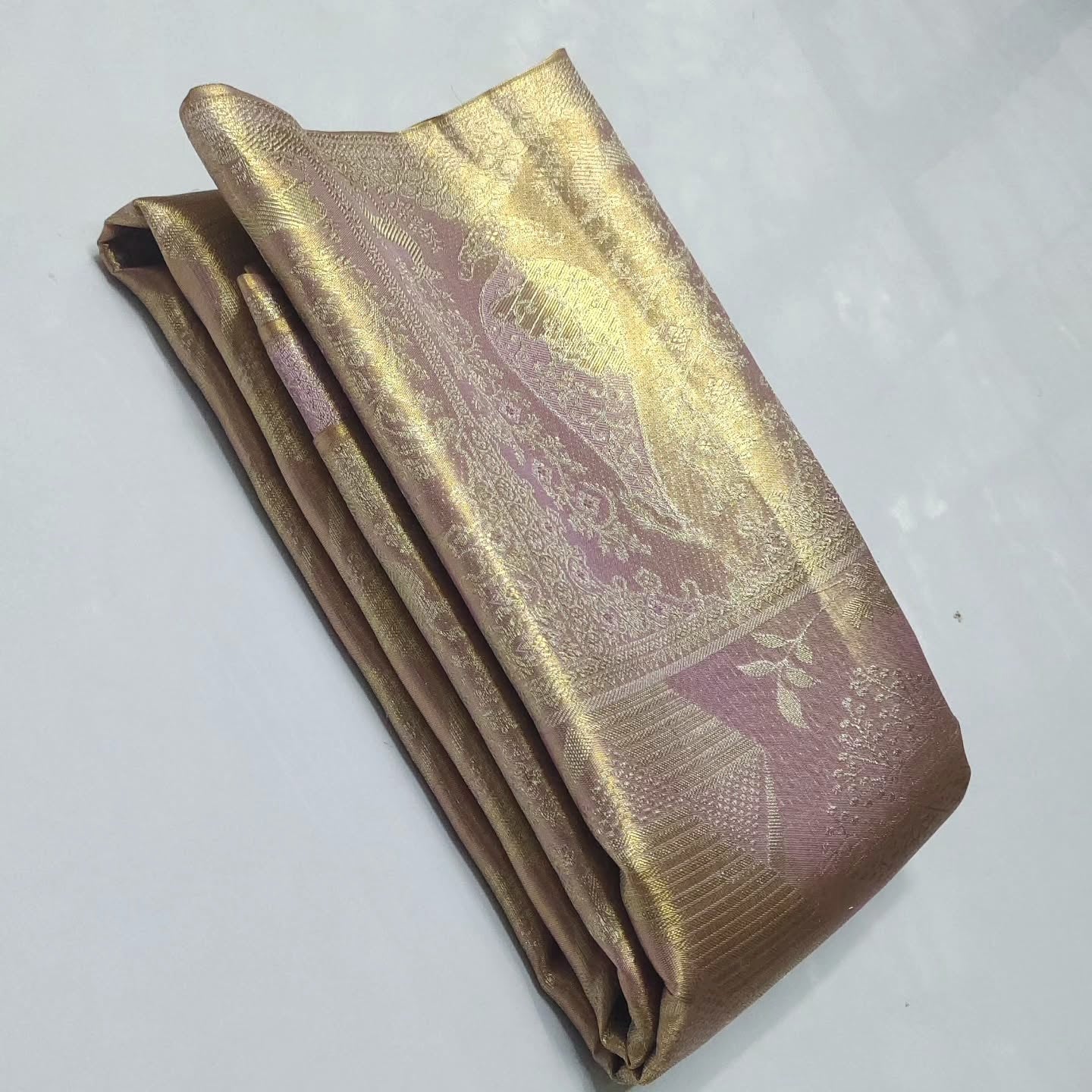 Close-up of the baby pink Kanchipuram tissue silk saree showcasing intricate gold brocade patterns and edge-to-edge Meenakari work.
