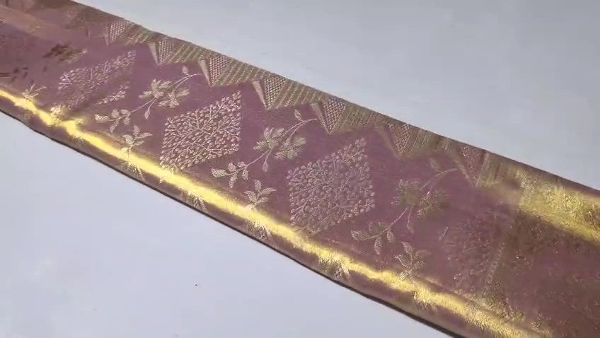 Close-up of the baby pink Kanchipuram tissue silk saree showcasing intricate gold brocade patterns and edge-to-edge Meenakari work.
