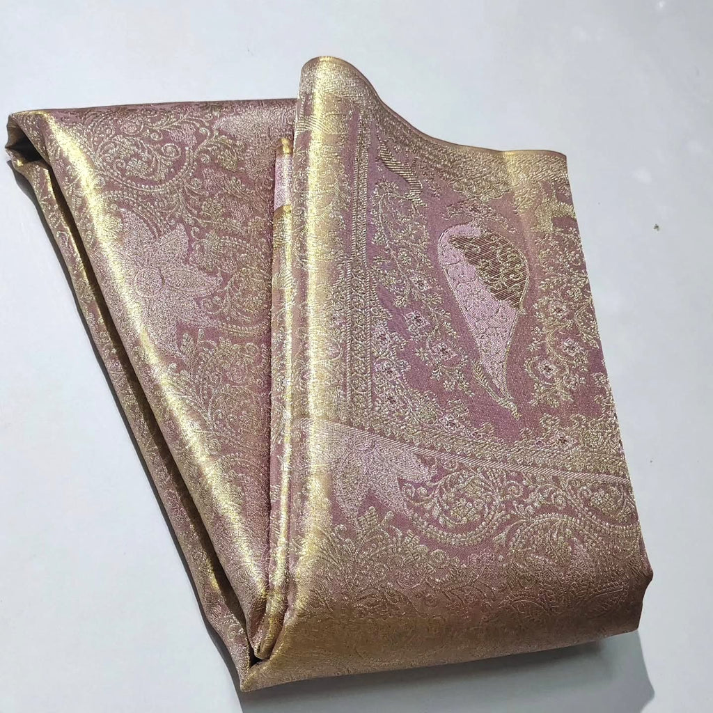 Neatly folded baby pink Kanchipuram handloom tissue silk saree displaying the rich pallu and shimmering metallic finish.