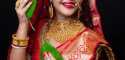 A beautiful happy Indian bride holding betel leaf , Bengali bride in traditional saree and makeup